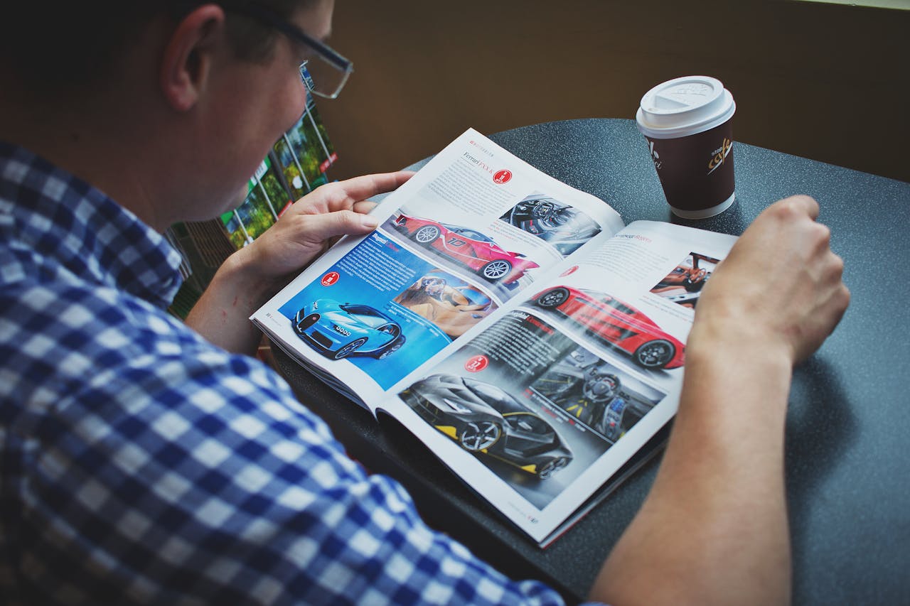 gallery-1 Adult man enjoying coffee while reading a car magazine. Perfect lifestyle image.